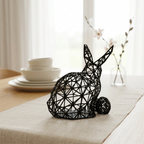 Sculpture de lapin noir sur une table en lin