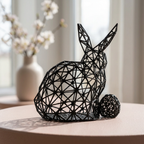 Sculpture de lapin noir près d’une fenêtre fleurie