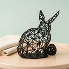 Sculpture de lapin noir dans un décor pastel