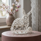 Sculpture de lapin blanc près d’une fenêtre fleurie