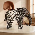 Sculpture d’éléphant noir dans un intérieur aux murs d’argile